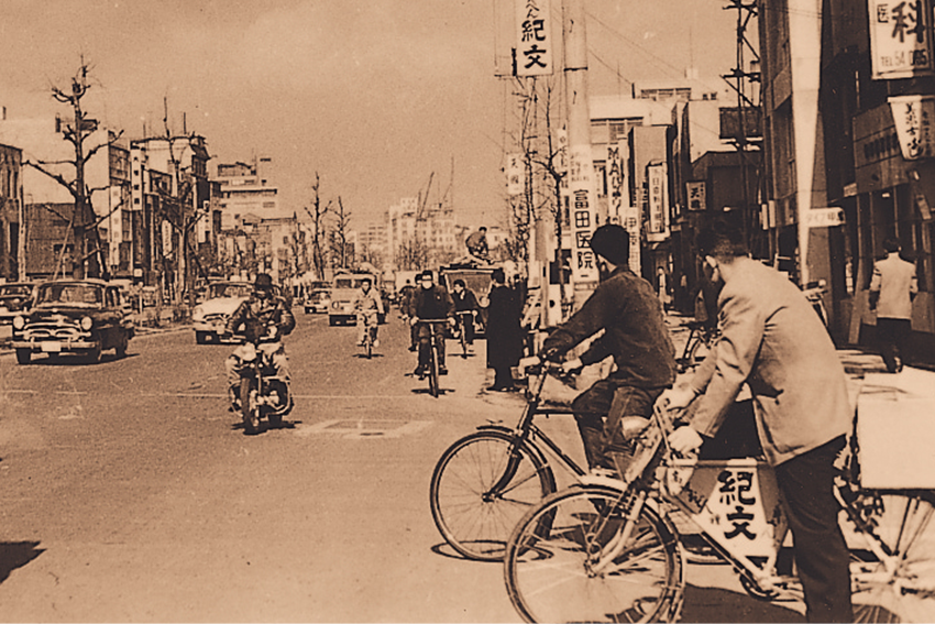 東京・昭和通りの電柱袖看板　手前は配達に使われた紀文の自転車