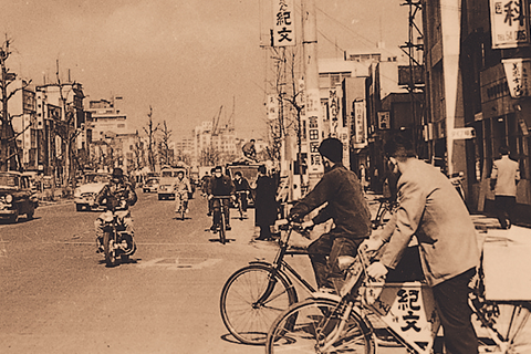 A Kibun signboard hanging on a telephone pole on Showa Street and a Kibun delivery bicycle in the foreground