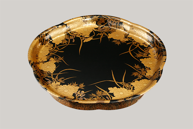 A flower-shaped tray with ”shikunshi” design in makie